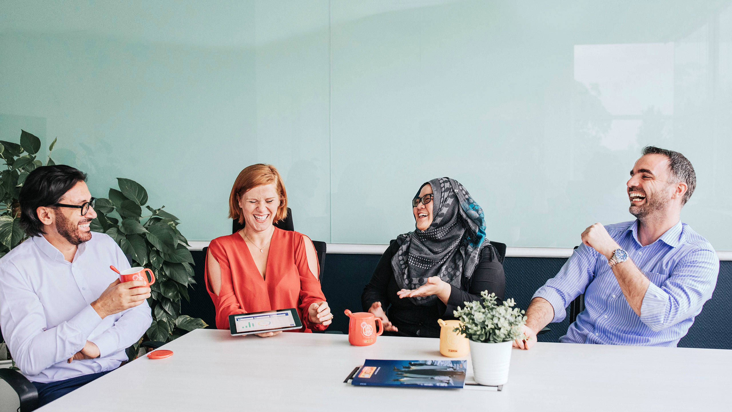 Four people sitting at a table laughing